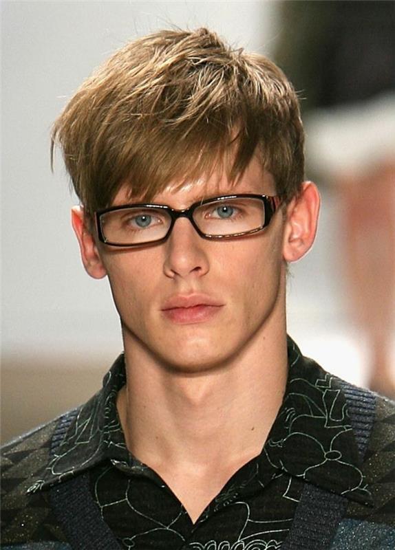 trumpas berniuko kirpimas ir šukuosena su asimetriškais kirpčiukais, krintančiais ant kaktos, akiniai, šviesiaplaukis berniukas