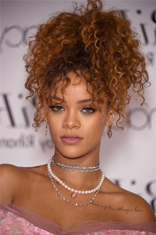 Rihanna ilgais variniais rudais plaukais surišta į aukštą arklio uodegą su kabančiomis spynomis ant veido