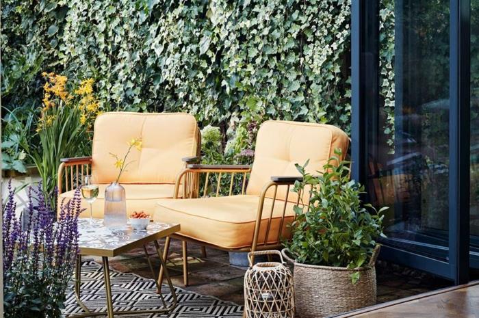 Geltoni foteliai deko terasa, kraštovaizdžio sodo terasa lauke violetinės ir oranžinės gėlės, nespalvotas geometrinis kilimas