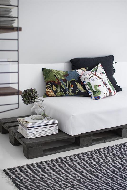 beyaz şilte ve uyumsuz baskılı minderlerle hoş bir kontrastta gri renkte yeniden boyanmış palet kanepe