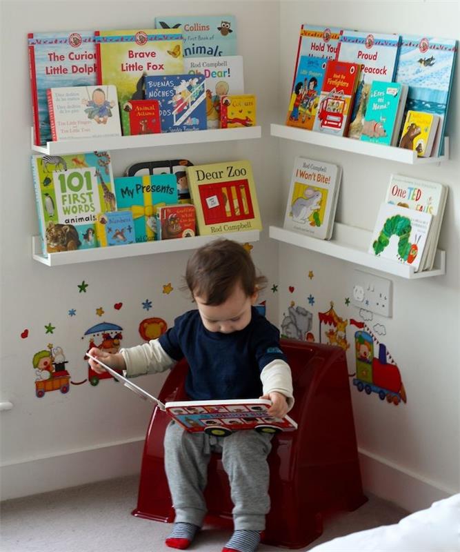 skaitymo kampiniai montessori žaidimai su mažu foteliu ir knygomis, saugomomis žemose lentynose, deko lipdukas vaikų kambaryje