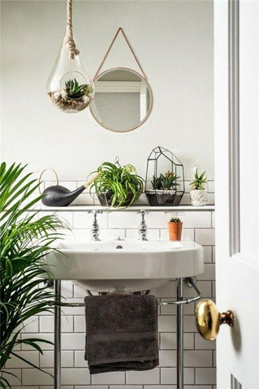 žalias vonios kambarys, didelė senovinė balta kriauklė, pakabinamas veidrodis, pusiau balta plytelių siena, pusė kreminės baltos spalvos, vidutinio dydžio palmė
