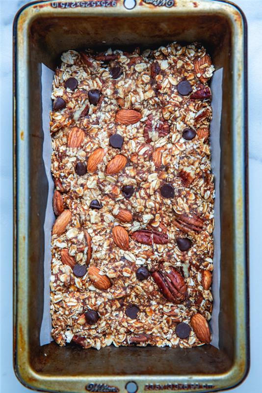kako narediti domačo beljakovinsko ploščico z ovsenimi kosmiči, arašidi, mandlji, čokoladnimi sekanci in arašidovim maslom