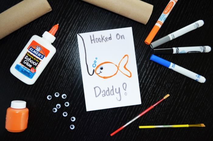 Ideja za darilo za očetovski dan za vrtec, primer čestitke iz belega papirja z risbo zlate ribice