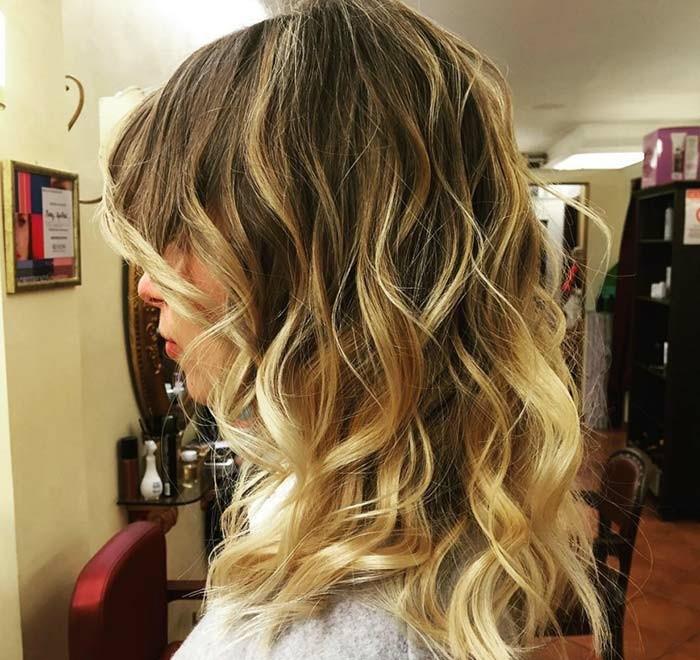 una ragazza con un uzun bob alla moda e dei balayage biondi su capelli castani