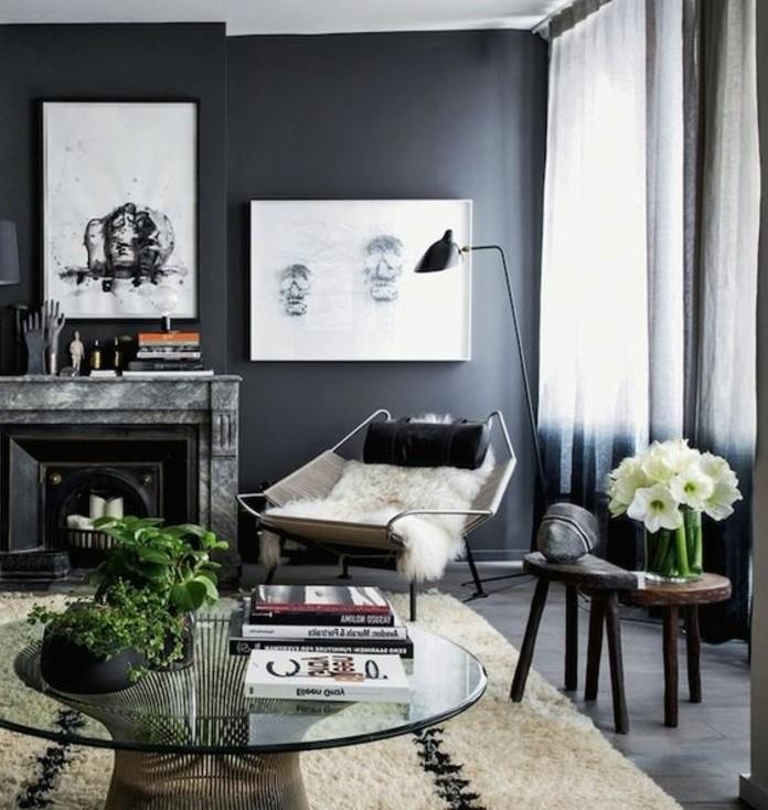 Idee arredamento soggiorno, parete di colore grigio, tavolino basso rotondo di vetro