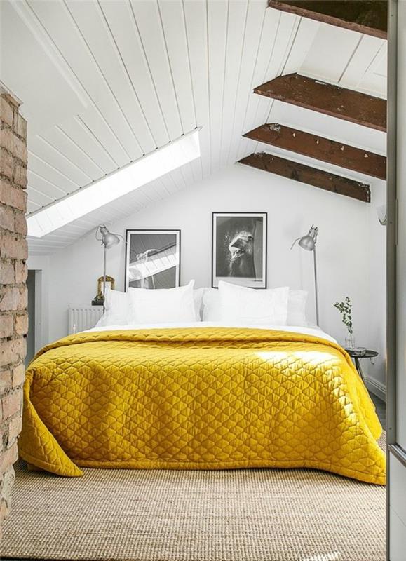 kırmızı tuğla duvar, sarı süslemeli yatak, ahşap kirişler, beyaz tavan ve duvarlar, mobilyalı çatı katı