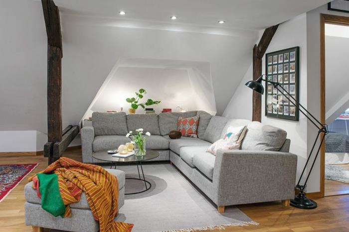 İskandinav oturma odası, gri köşe kanepe, gri halı, parlak kaplamalı gri tabure, ahşap zemin