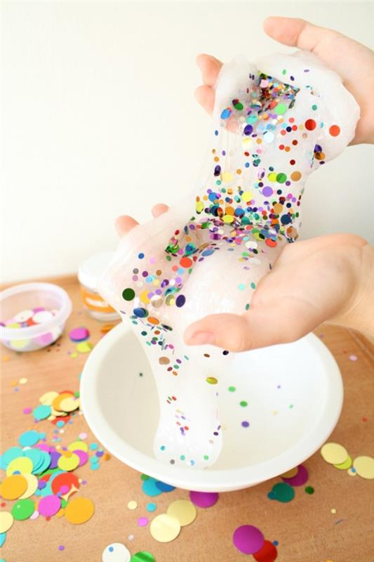 Slime fatto in casa di colore bianco con decorazione di piccoli pezzettini colorati di konfeti