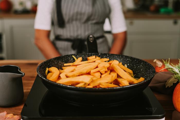 Ricetta vellutata di zucca, fette di zucca, padella su un fornello elettrico