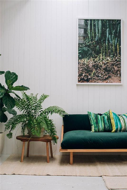 balta svetainė, pritaikyta gamtos dekoravimui ir ančių žalios ir smaragdo žalios spalvos atspalviams, smaragdo žalia aksominė sofa su atspausdintomis pagalvėlėmis