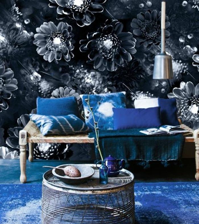 kako-oblikovati-dnevno sobo-steno-ozadje-s-cvetličnimi-indigo-vzorci-modre-blazine-lesena-klop-mizica-oblikovanje-zanimivo