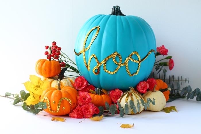 lengvas Helovino moliūgų dekoravimas ar pjaustymas, mėlyna spalva nudažytas moliūgų raštas su Helovino raidėmis aukso spalvos akmenukais