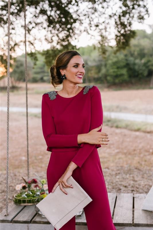 elegantna in elegantna vizija v elegantnem ženskem kombinezonu bordo barve z majhnimi srebrnimi detajli na ramenih
