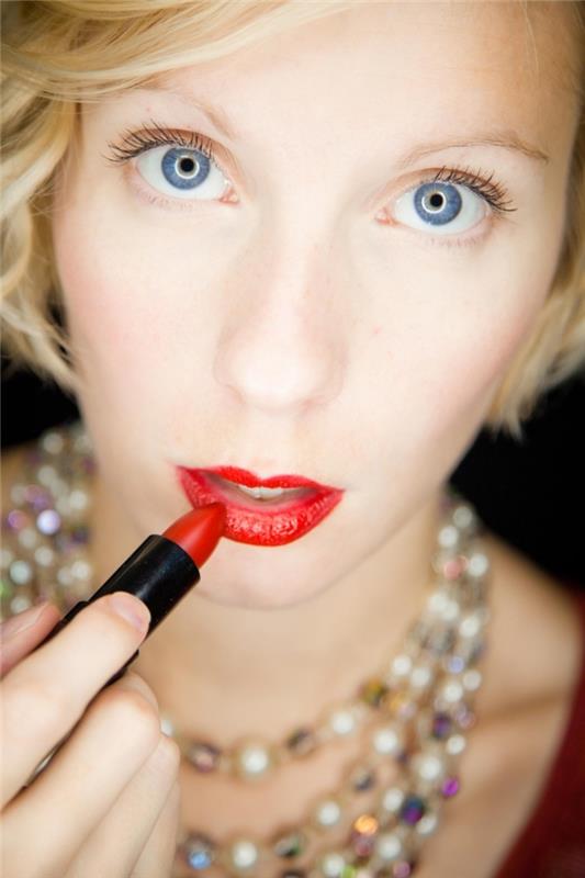 tanka ustnica, kratka blond frizura s stranskimi šiški, ličila za modre oči z rdečo šminko