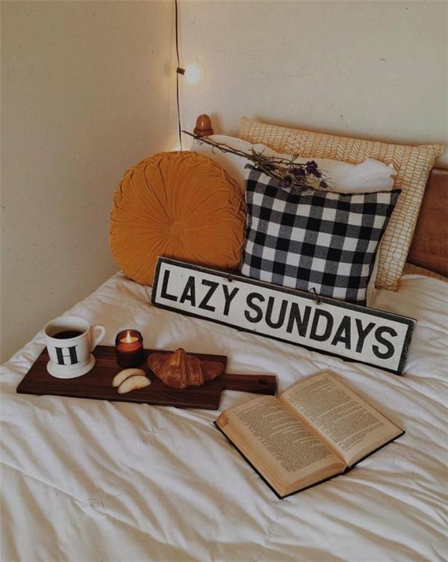 antklodės užvalkalas, knyga ir pusryčiai su kava ant lovos, geltona pagalvė, languota pagalvė, lengva girlianda