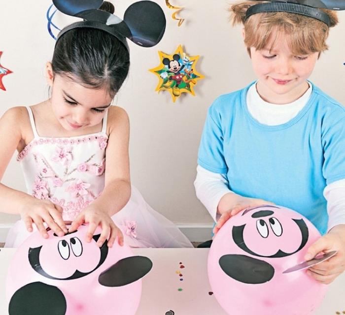 pembe bir balonu yapıştırmak için mickey mouse desenli çıkartmalarla nasıl süsleyebiliriz