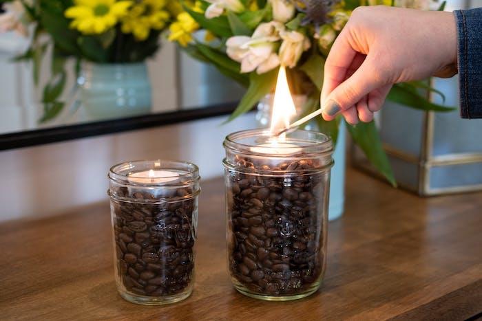 kaip sudeginti kavos tirščius du stiklinius indelius su uždegtomis žvakėmis