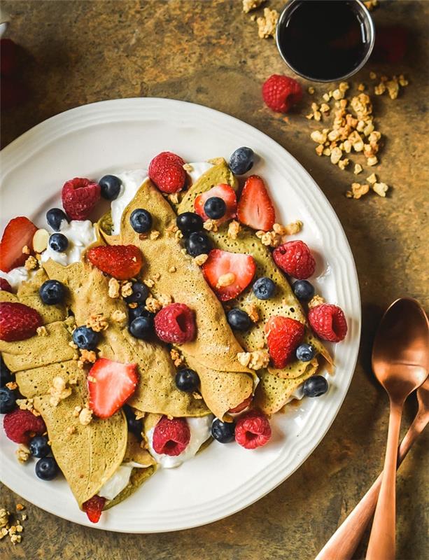 Yunan yoğurdu, kırmızı meyveler ve granola ile glutensiz kreplerden oluşan sağlıklı kahvaltı