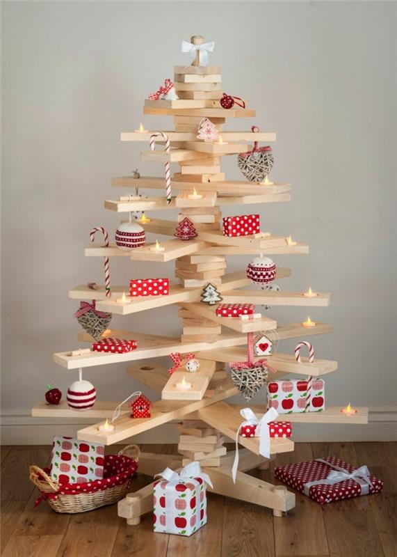 Beyaz ahşap kalaslarda Noel ağacı, dekoratif kağıda giydirilmiş küçük hediyeler, küçük led mumlar, küçük evler
