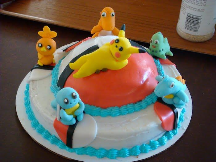 srčkan pikachu, domača sladica, rojstnodnevna torta, figurica iz marcipana, lesena miza, bela smetana