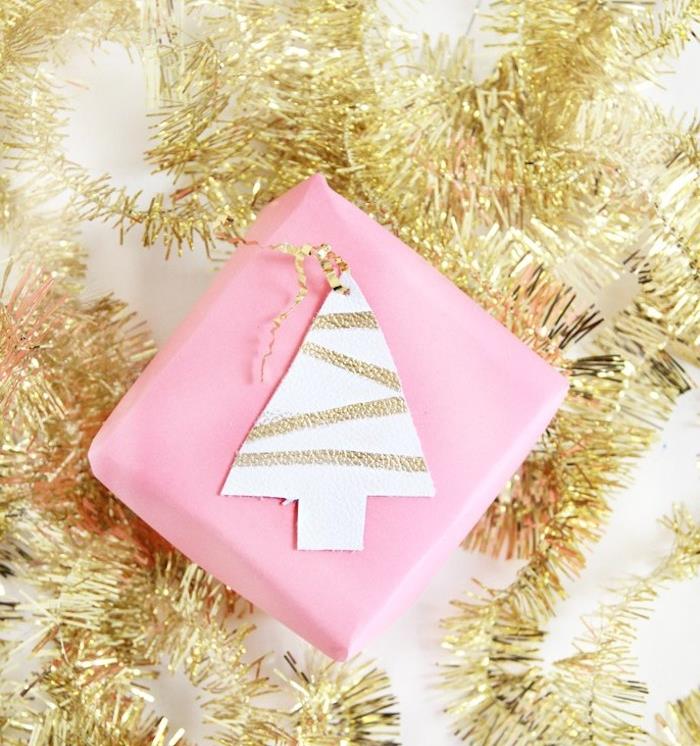 preprost božični darilni paket v roza barvi z usnjenim vzorcem božičnega drevesa, okrašenim z zlatimi črtami