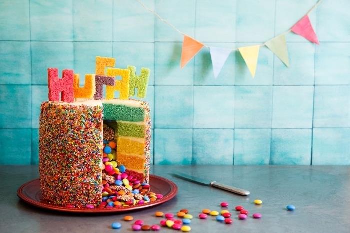 smartie kek tarifi piñata stili renkli sprinkles ve renkli sünger kekten kesilmiş harflerle dekore edilmiştir.