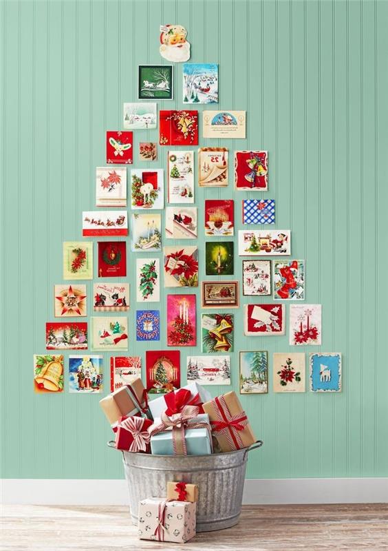 yeşil bir duvarda eski geri dönüştürülmüş Noel kartlarından bir Noel ağacı yapmak, kağıttan Noel dekorasyonu fikri