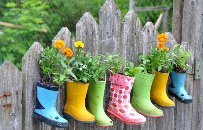 DIY dekoracija za vrt v recikliranih gumijastih škornjih različnih barv s posajenim cvetjem