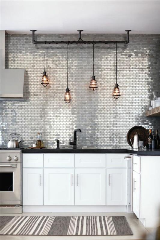 atnaujinkite savo virtuvę, perdažykite virtuvės spintelę, blizgią sieną, padengtą blizgančiais sidabro spalvos lapais, stačiakampį kilimėlį pilkos ir pastelinės rožinės spalvos, juodos spalvos metalo šviestuvus, keturias skaidraus stiklo lemputes