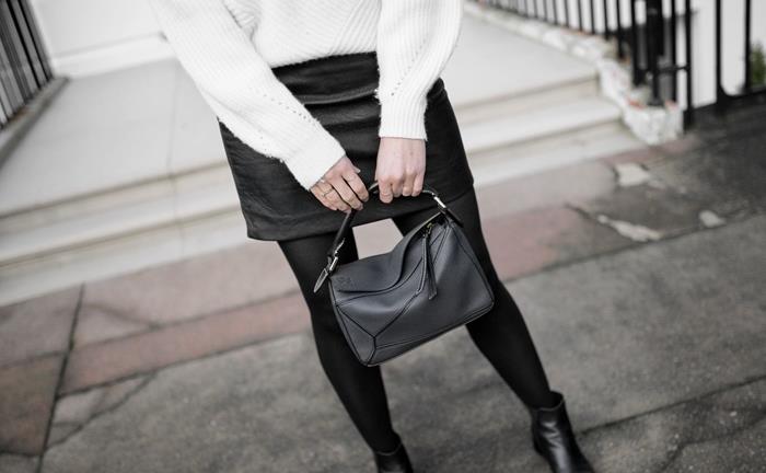 Kako nositi kratko črno usnjeno krilo z belim prevelikim puloverjem Črni usnjeni škornji Ženska zimska obleka v beli in črni barvi