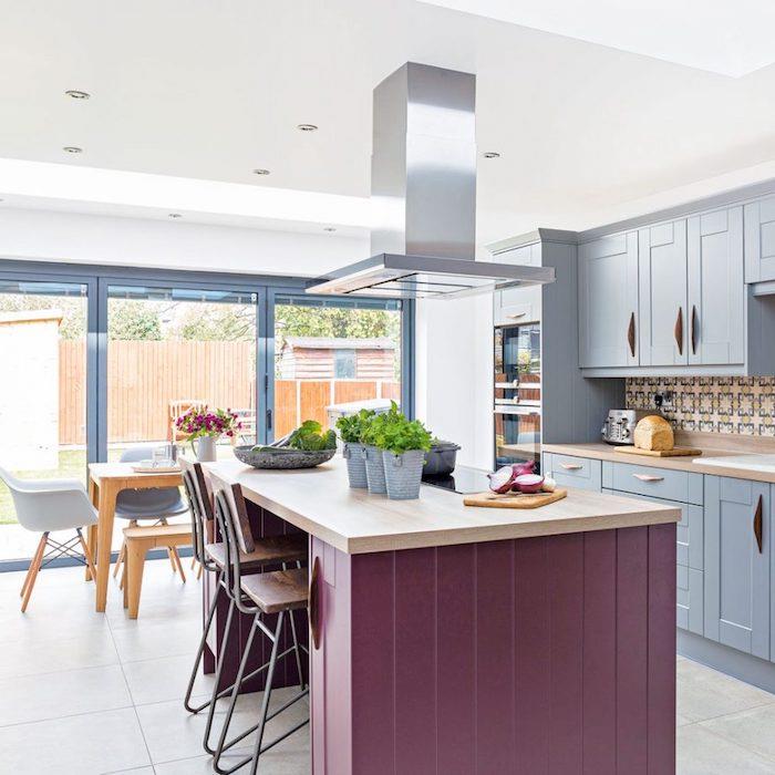 pertvarkykite savo virtuvę, pavyzdys virtuvės fasadas perdažytas mėlyna spalva, o stalviršis perdažytas violetine spalva, valgomojo zona su mediniu stalu ir suolu bei skandinaviškos kėdės