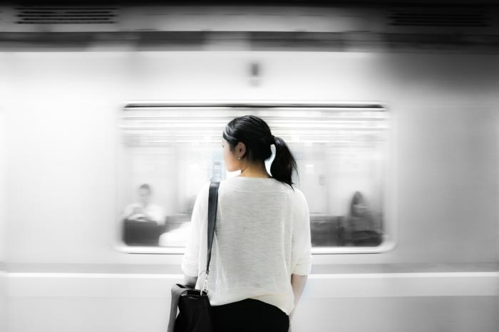 keliauja viešuoju transportu, jauna mergina priešais metro, mergina su baltais marškinėliais, juodos kelnės
