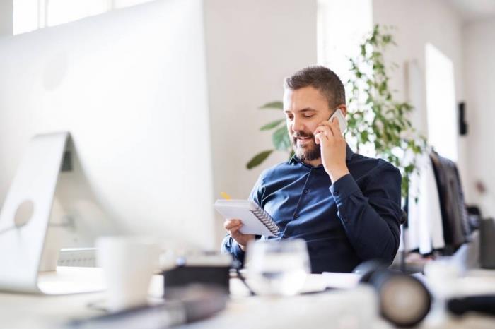 moški, ki govori po telefonu, delovno vzdušje, minimalistična pisarna, kako izolirati hrup v odprtem prostoru