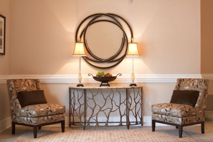 du pilki foteliai, originali sienų apdaila, meniška konsolė su dviem lempomis, paprasta įėjimo idėja