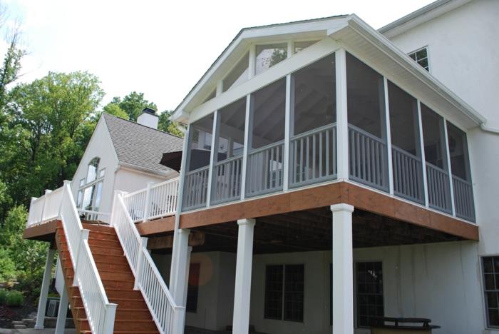 dvignjena terasa, hiša z belo fasado, leseno stopnišče, bela ograja, karirana okna