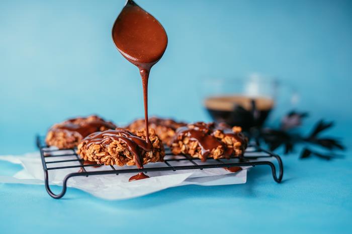 Biscotti colazione leggeri, biscotti all'avena, cucchiaio con nutella, tazza di caffè