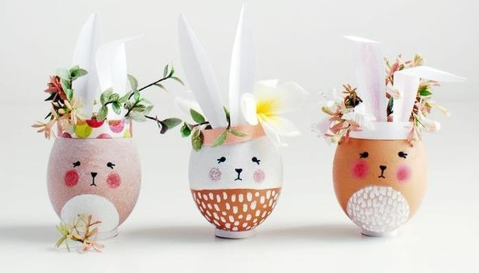 Paskalya tavşanı yumurta kabuğu, özel yumurta kabukları, kağıt kulaklar, taze çiçeklerle dolu küçük vazolar örneği