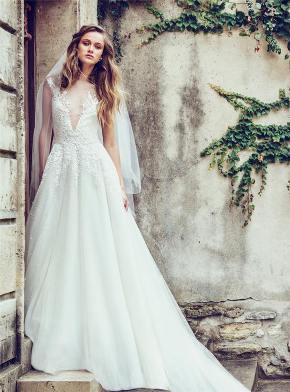 2018 metų vestuvių suknelės tendencija, platėjantis sijonas ir krūtinėlė papuošti gėlių raštais su asimetrine iškirpte