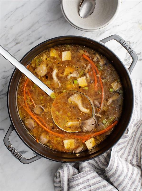 Pentola con minestra di funghi, mestola con zuppa, cena sfiziosa e veloce per amici