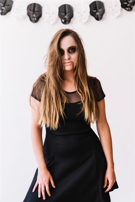 „Pasidaryk pats“ vampyrų apranga Helovino moteriai, moteris vampyrė atrodo juodos spalvos midi suknele ir lengvu naminiu Helovino makiažu