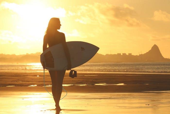 Gün batımında sörfüyle sahilde sörfçü kız, manzara duvar kağıdı, dünyamızın güzelliğini keşfedin