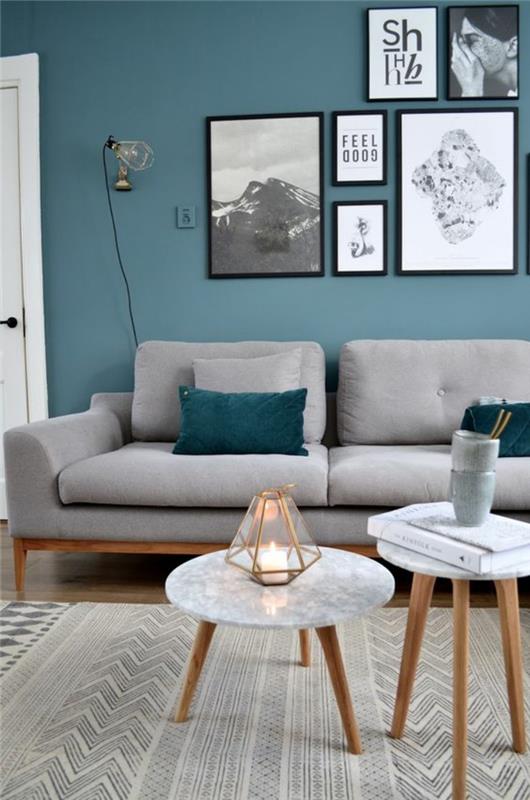 bencinsko modra dnevna soba s stenami in pohištvom v svetlo sivi in ​​beli barvi za dve okrogli mizi različnih velikosti
