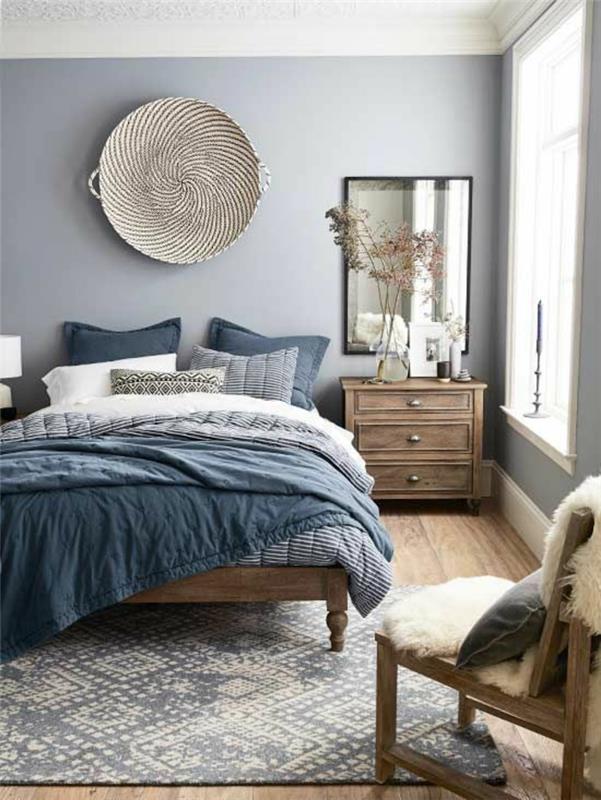 modra dekoracija spalnice za odrasle z veliko pleteno košaro iz trsa v etničnem slogu kot stenska dekoracija velika postelja s sivo modrim perilom