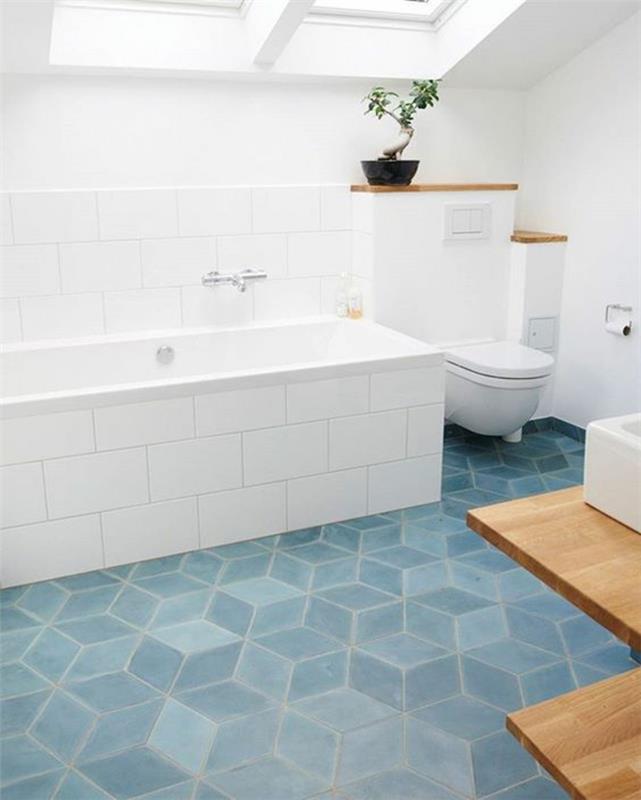 odtenek sivo modre na ploščicah poševne kopalnice z belim pohištvom in kadjo, prekrito z belimi ploščicami