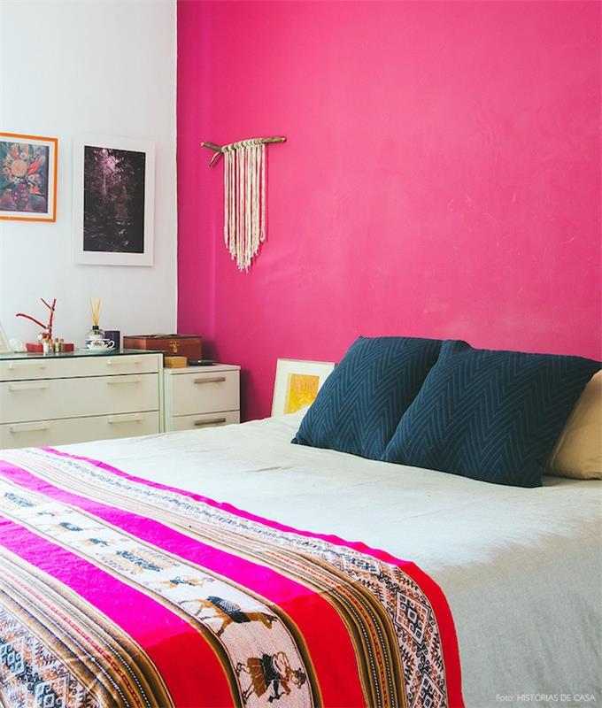 slikanje spalnice za odrasle z rožnato naglašeno steno fuksije, črne blazine, posteljna prevleka z orientalskim vzorcem, bela omara, stenska dekoracija iz makrameja