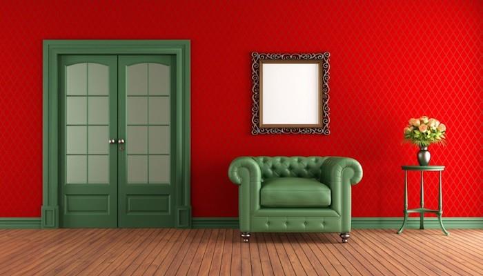 rdeča komplementarna barva zelena, kavč in zelena vrata, rdeča stenska obloga, vintage ogledalo, parket iz svetlega lesa