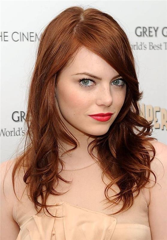 varinė plaukų spalva Emma Stone smėlio spalvos suknele ir raudonomis lūpomis