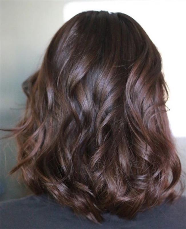 moters nuotrauka su blizgiais rudais plaukų dažais ant ilgų garbanotų plaukų