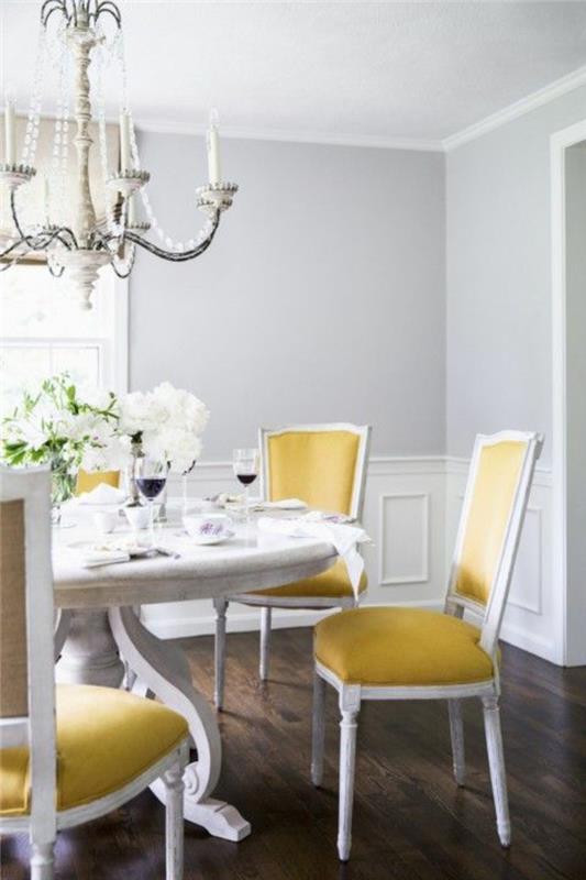 büyük bir klasik barok avize ve sarı ve beyaz sandalyeler ile bir yemek odasında inci grisi